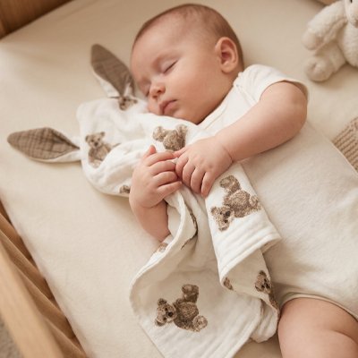 Bebe dort a cote de son doudou marron