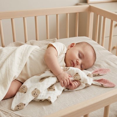 Bebe dort accote a son doudou rose