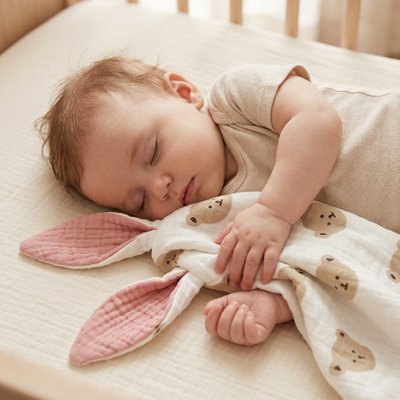 Bebe dort proche du doudou rose
