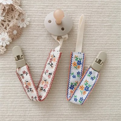 Attache tetine innovant avec des dessins de fleurs